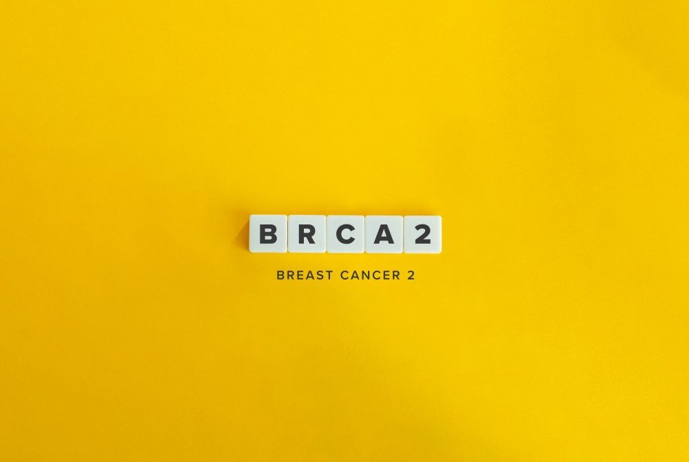 Letter tiles spelling BRCA2 on a yellow background